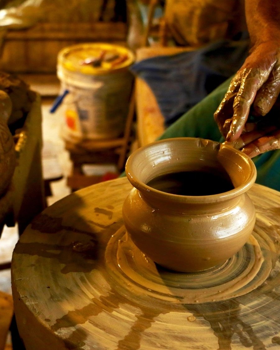 A potter shaping a vessel on a wheel
